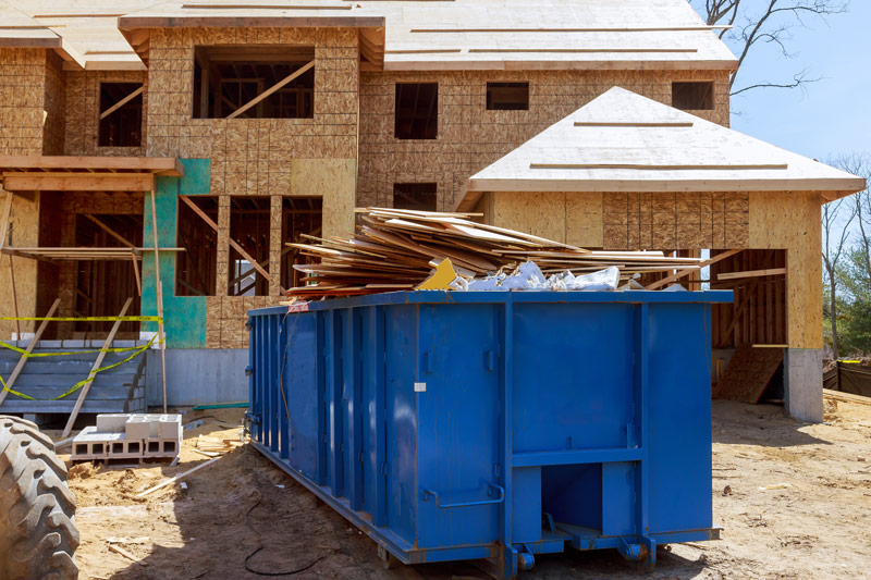Construction Debris Removal with Blue Dumpster Outside of New Build Home in Costa Mesa, CA
