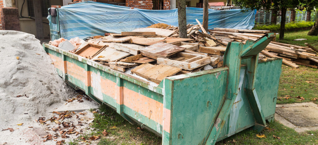 Construction Debris Removal in Irvine, CA, with a Dumpster Filled with Construction Junk